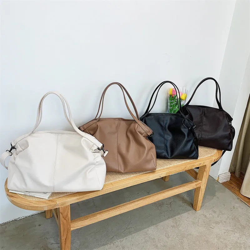 Large soft black PU leather messenger tote bag with a shoulder strap, showing zipper and phone pocket.