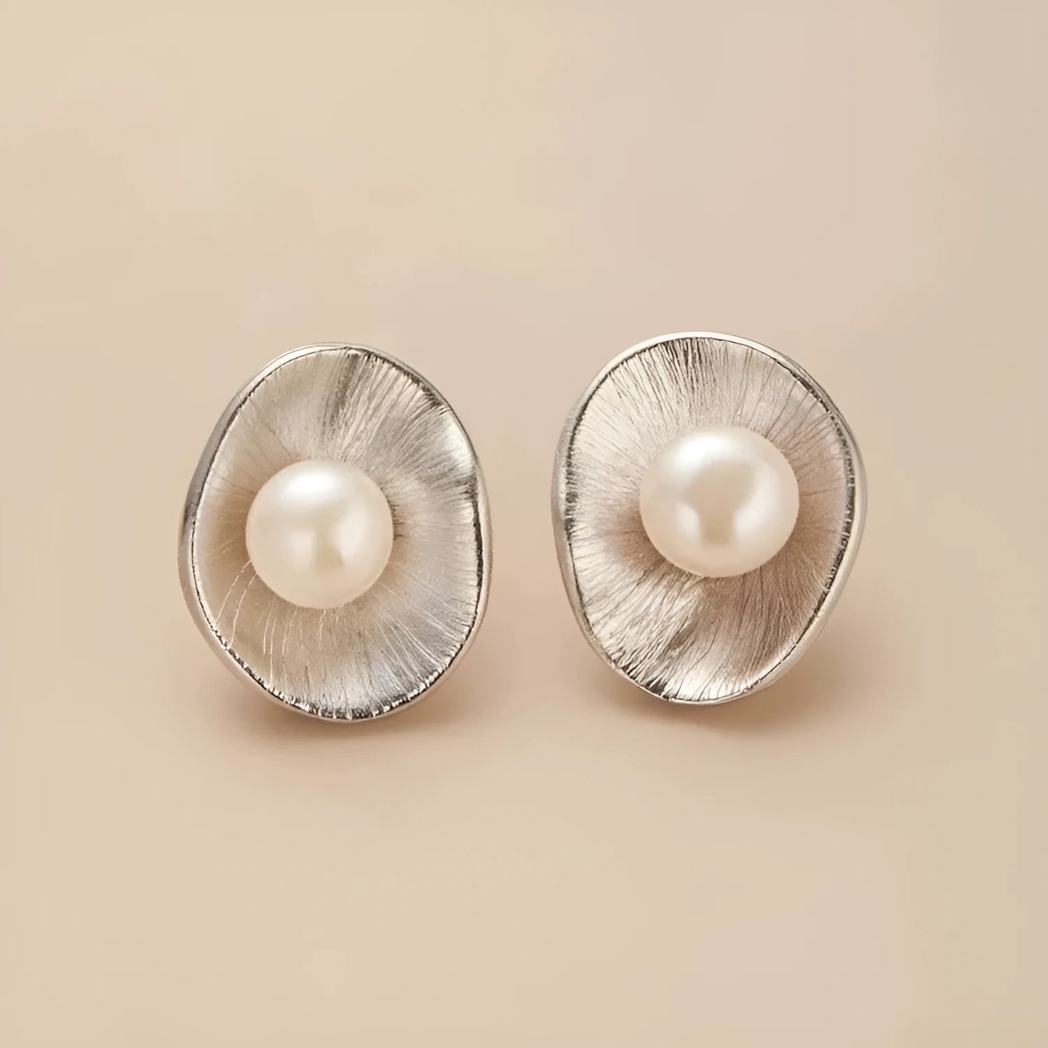 A pair of gold-coloured geometric sterling silver ear studs featuring pearl accents.