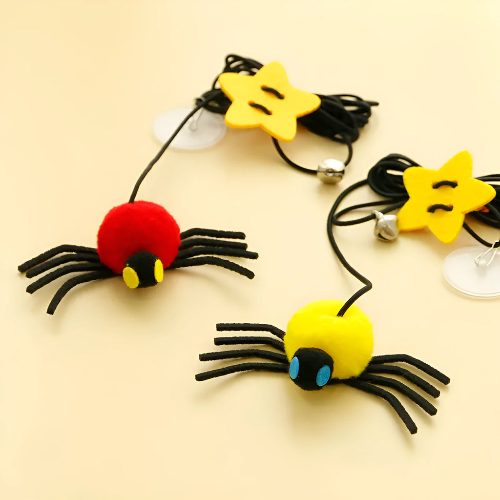 Cat hanging door toy with elastic rope, feather, bell and spider attachment on a white door.